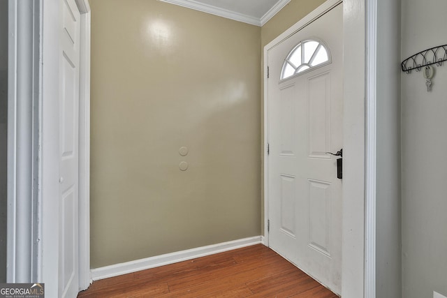 foyer entrance with crown molding, dark wood finished floors, and baseboards