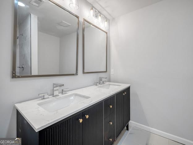 bathroom featuring baseboards, visible vents, double vanity, a sink, and marble finish floor