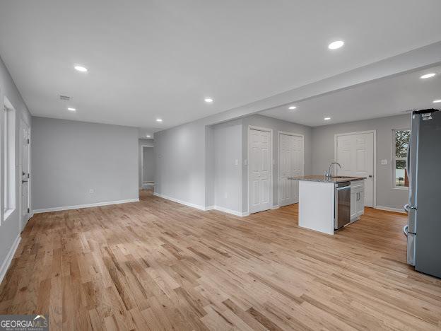 interior space with recessed lighting, baseboards, light wood-style floors, and appliances with stainless steel finishes