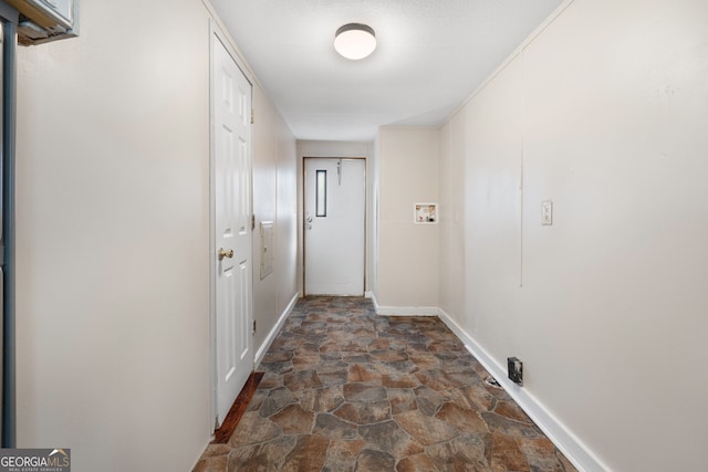 doorway with stone finish flooring and baseboards