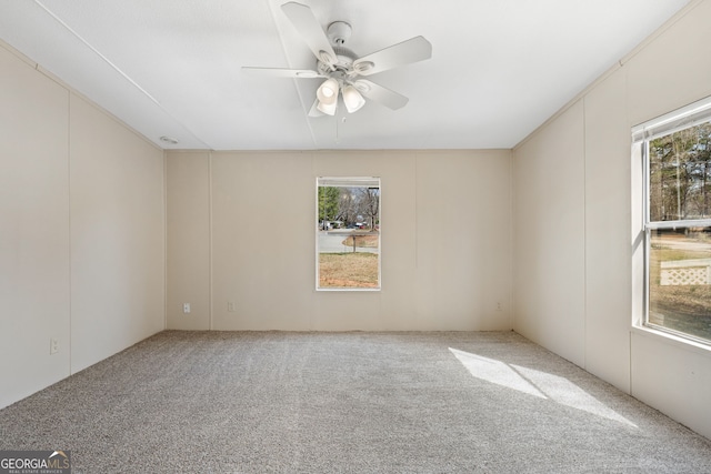 carpeted spare room featuring ceiling fan