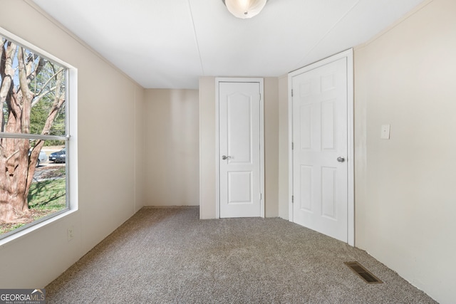 unfurnished bedroom featuring carpet and visible vents