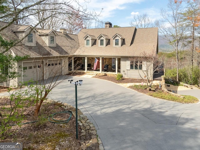 new england style home with concrete driveway and a chimney