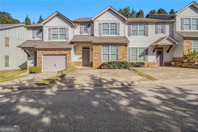 view of property with stone siding and concrete driveway