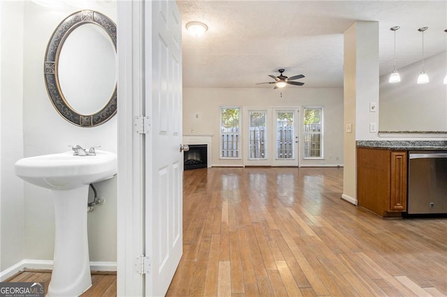 interior space featuring wood-type flooring, a fireplace, baseboards, and ceiling fan