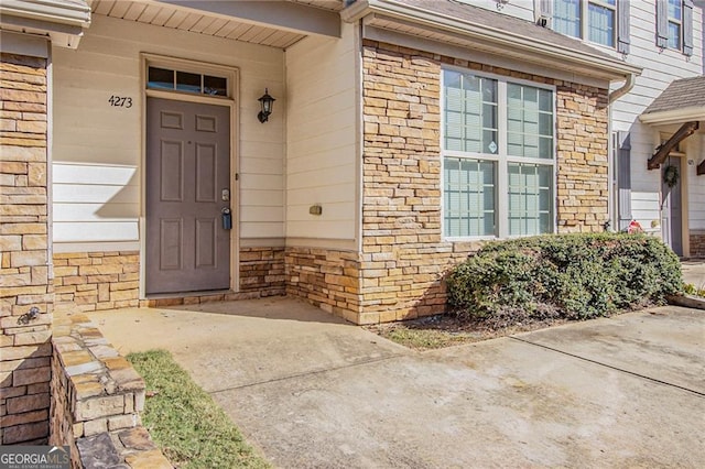 doorway to property with stone siding