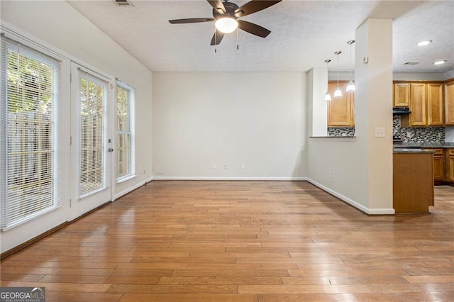 unfurnished living room with baseboards, ceiling fan, a textured ceiling, light wood-type flooring, and recessed lighting