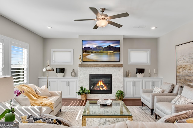 living room with visible vents, a ceiling fan, wood finished floors, a fireplace, and recessed lighting