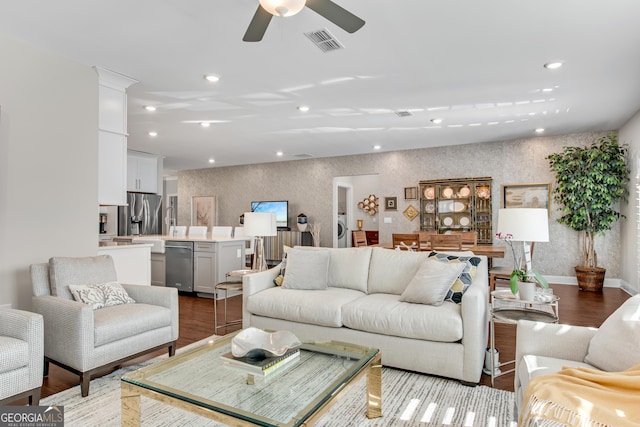 living room featuring wallpapered walls, baseboards, visible vents, wood finished floors, and recessed lighting