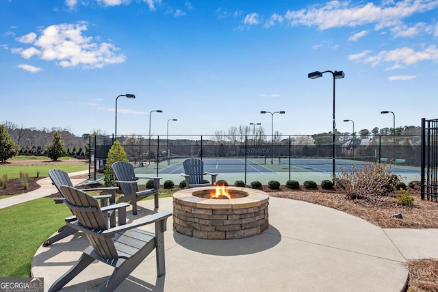 view of sport court featuring a fire pit and fence