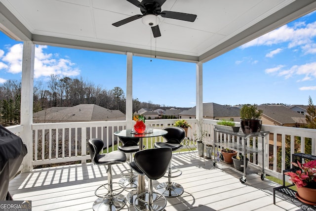 deck with a residential view and a ceiling fan