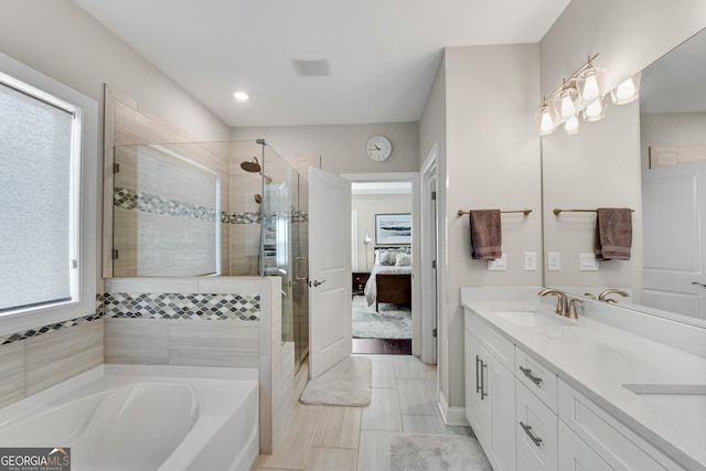 ensuite bathroom with double vanity, connected bathroom, a sink, a shower stall, and a bath