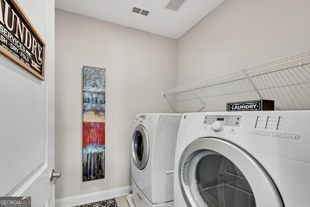 clothes washing area featuring laundry area, baseboards, visible vents, and washer and dryer