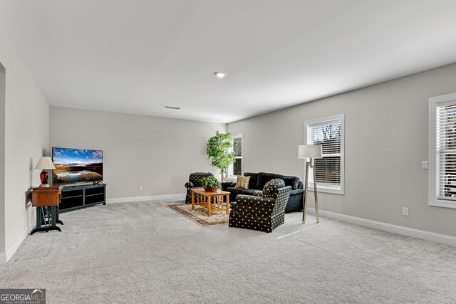 sitting room featuring a healthy amount of sunlight, visible vents, baseboards, and carpet flooring