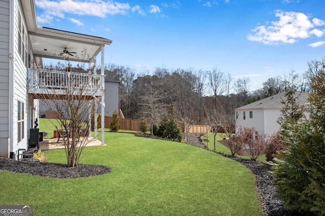 view of yard featuring ceiling fan, a patio, fence, and a balcony