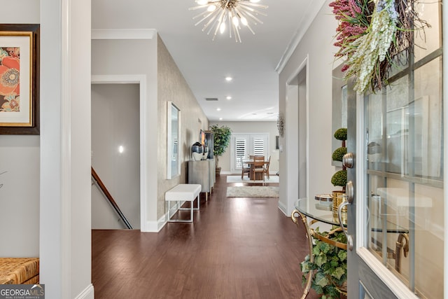 foyer featuring crown molding, a chandelier, dark wood-type flooring, and recessed lighting