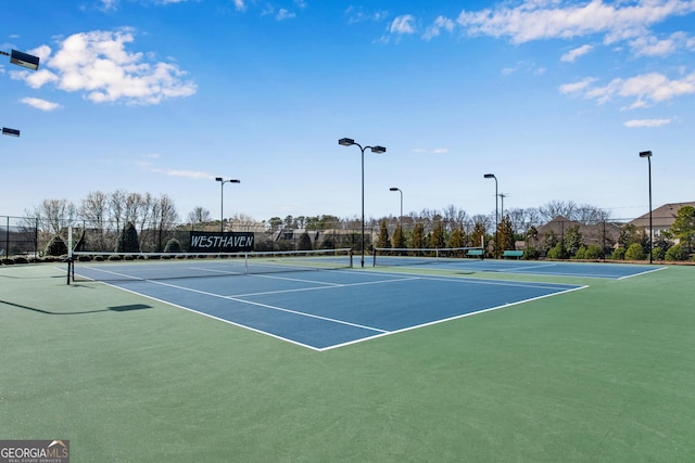 view of tennis court featuring fence