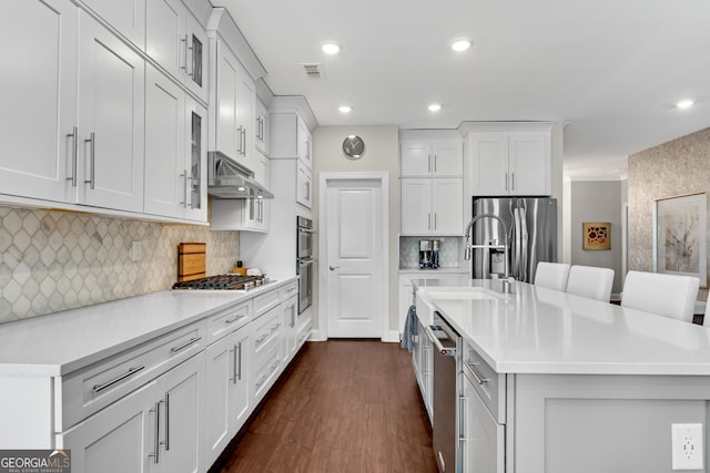 kitchen with appliances with stainless steel finishes, light countertops, visible vents, and under cabinet range hood