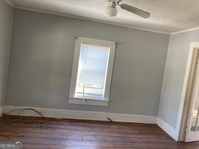 spare room featuring baseboards, a textured ceiling, ornamental molding, and wood finished floors