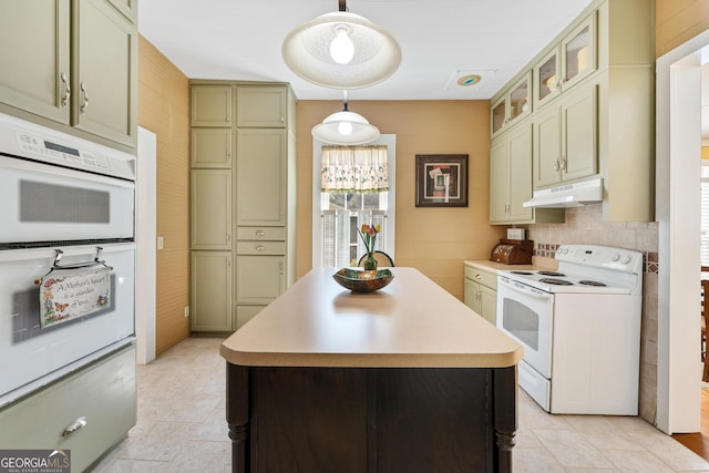 kitchen with a center island, light countertops, hanging light fixtures, white appliances, and under cabinet range hood