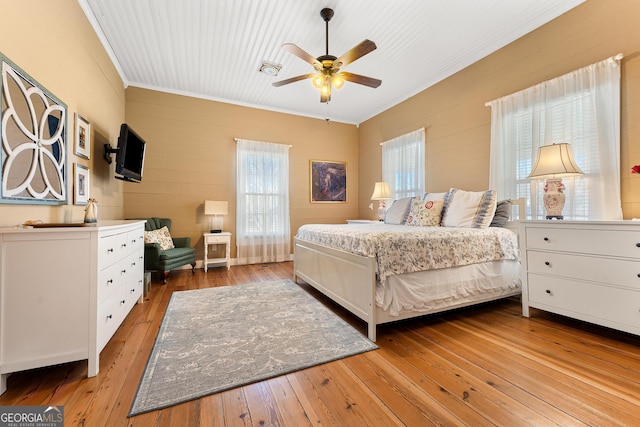 bedroom featuring ceiling fan, crown molding, and hardwood / wood-style flooring