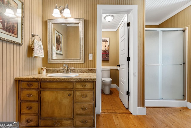 bathroom with vanity, a shower stall, toilet, and wood finished floors