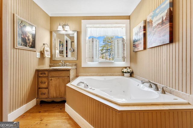 full bath featuring wallpapered walls, vanity, a tub with jets, and wood finished floors