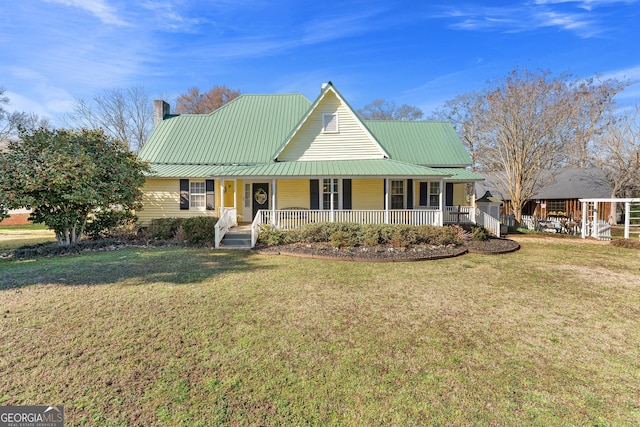 farmhouse inspired home featuring covered porch, a chimney, metal roof, and a front yard