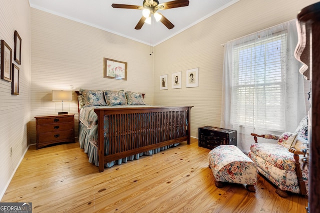 bedroom with ceiling fan, ornamental molding, wood finished floors, and wallpapered walls