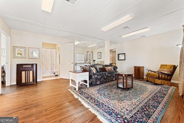 living area featuring wood finished floors, visible vents, and baseboards