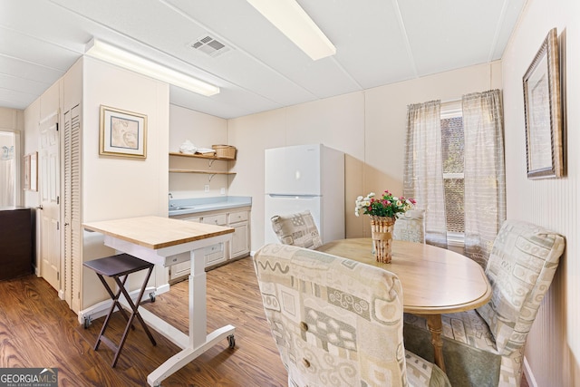 dining space featuring light wood-style floors and visible vents