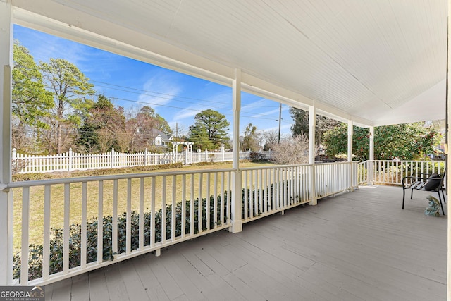 wooden deck with covered porch, a lawn, and fence private yard