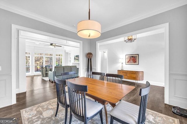 dining room featuring wood finished floors, ornamental molding, and ceiling fan with notable chandelier