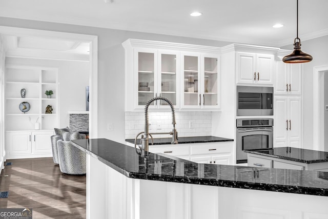 kitchen with glass insert cabinets, dark stone counters, appliances with stainless steel finishes, white cabinets, and dark wood-style flooring