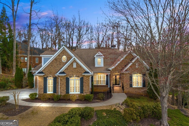 view of front of home featuring brick siding and concrete driveway