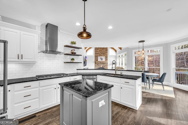 kitchen featuring wall chimney range hood, dark wood-style floors, stainless steel appliances, and a sink