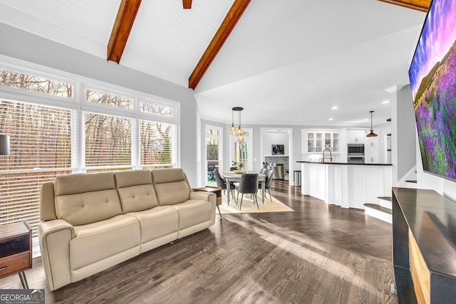 living area featuring beam ceiling, recessed lighting, dark wood-type flooring, and high vaulted ceiling