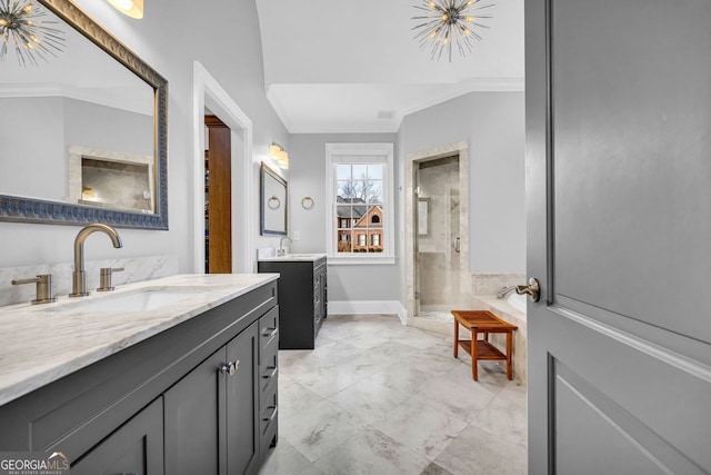 full bathroom with a sink, two vanities, a stall shower, and crown molding