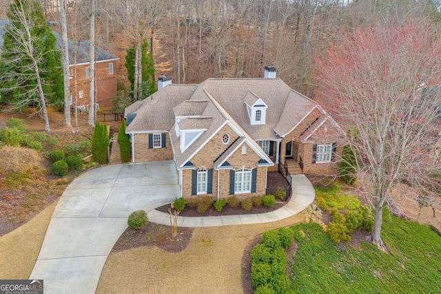 view of front facade with brick siding and concrete driveway