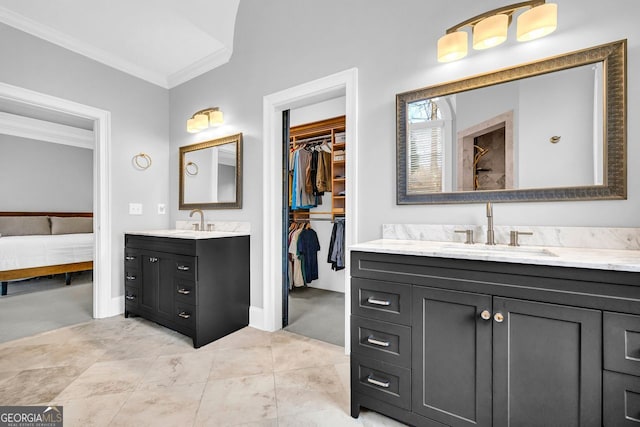 bathroom featuring crown molding, two vanities, tiled shower, and a sink