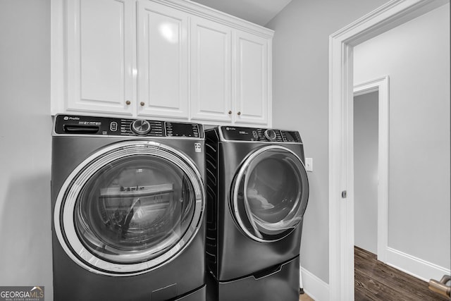 washroom featuring cabinet space, wood finished floors, separate washer and dryer, and baseboards