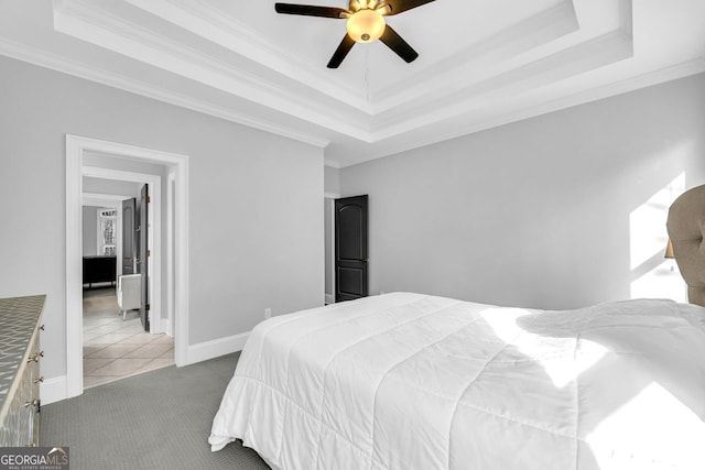 bedroom with crown molding, ceiling fan, baseboards, carpet flooring, and a raised ceiling