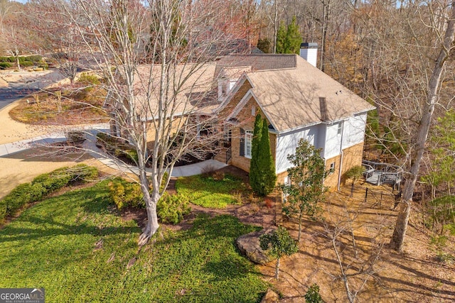 view of property exterior featuring a chimney and a shingled roof