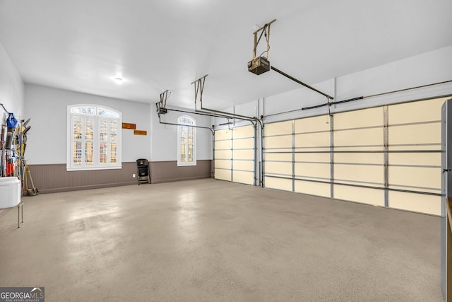 garage with a garage door opener and wainscoting