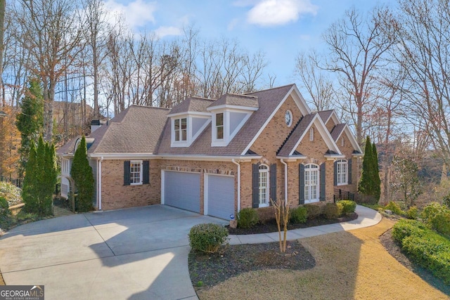 view of front of home featuring a garage, brick siding, and driveway