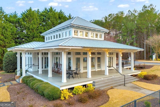 rear view of house with metal roof, french doors, and a standing seam roof