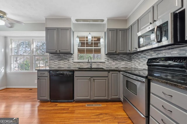 kitchen with stainless steel appliances, gray cabinets, and a sink