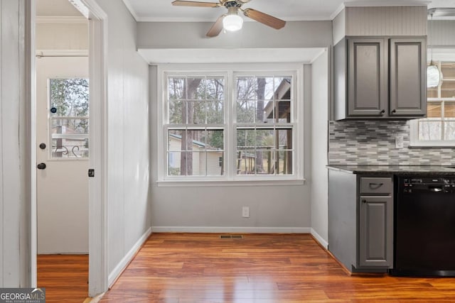 kitchen with ornamental molding, dark countertops, gray cabinets, and dishwasher