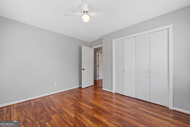 unfurnished bedroom featuring ceiling fan, a closet, wood finished floors, and baseboards