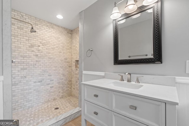 bathroom featuring a tile shower and vanity